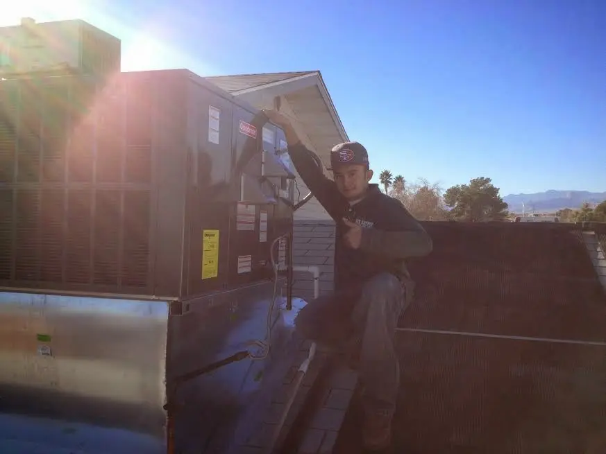 HVAC technician performing Air Duct Repair on a rooftop unit in Palmyra